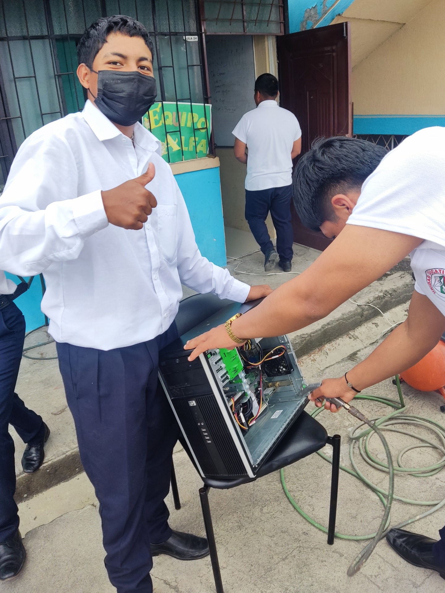 Estudiantes haciendo la limpieza del computador 